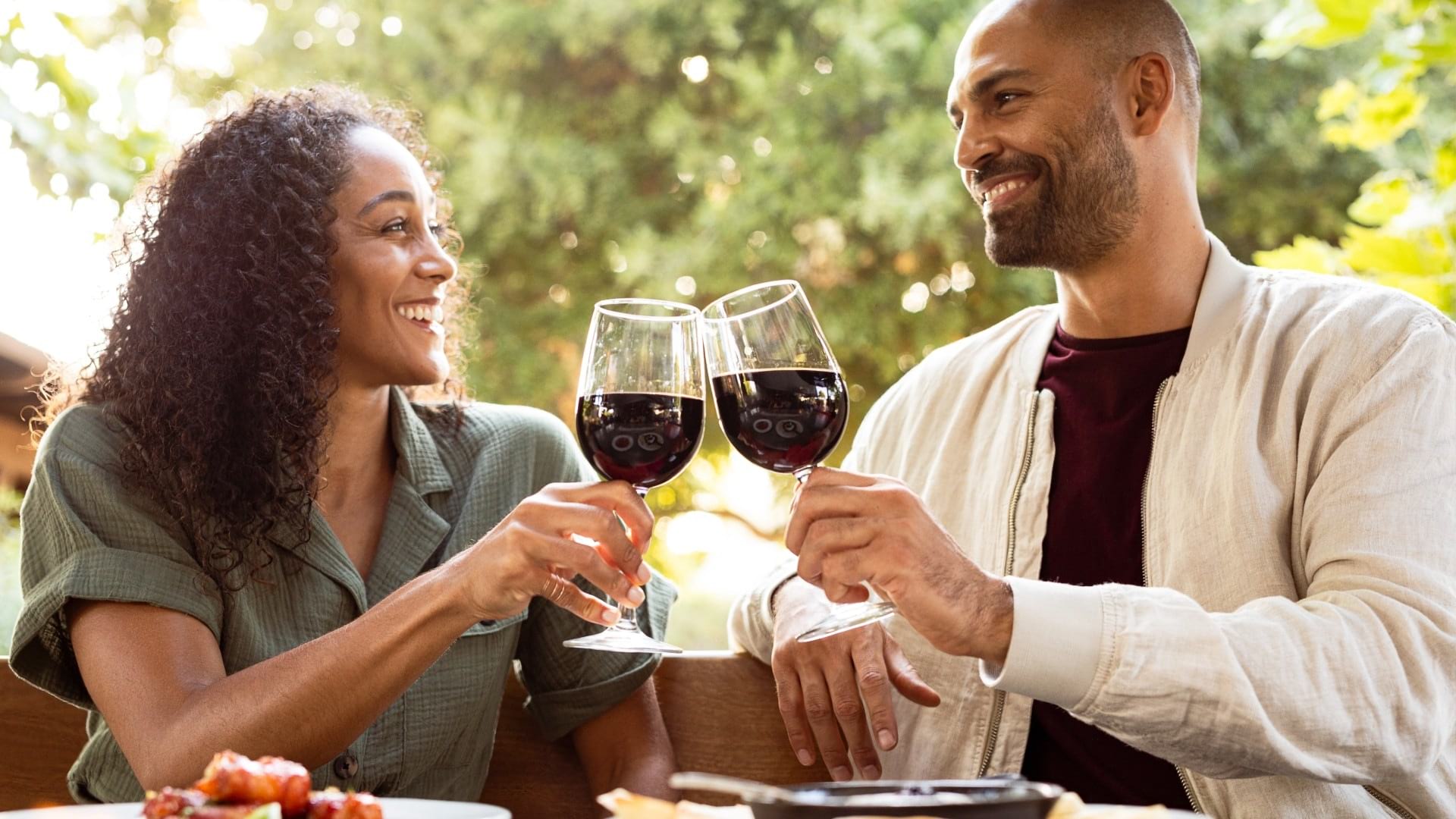 two people celebrating an occasion with wine glasses and in an outdoor area